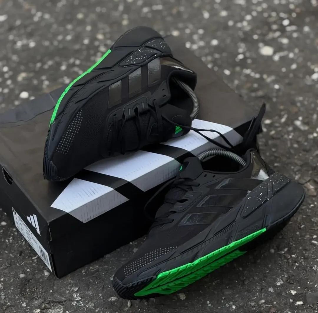 Tenis negros de running para caballero con detalles verde neón
