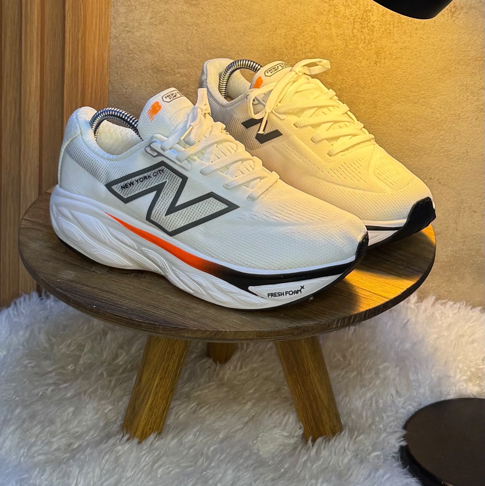 Tenis blancos de running para caballero con detalles negros y naranjas